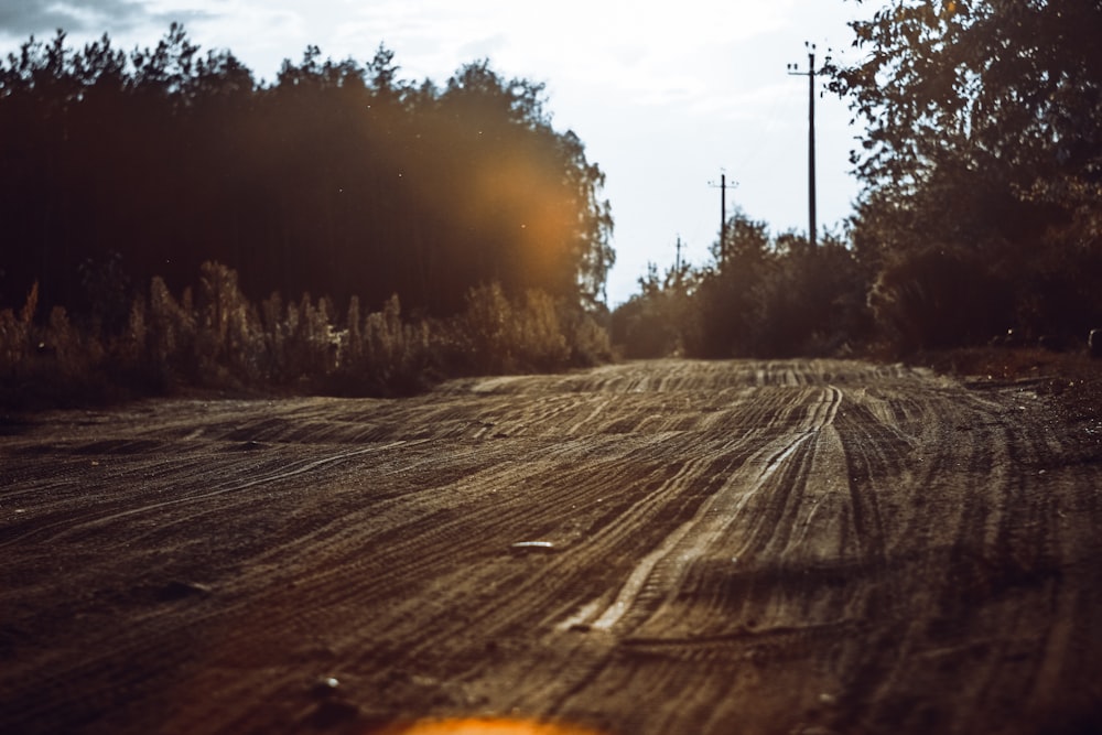 a dirt road with trees in the background