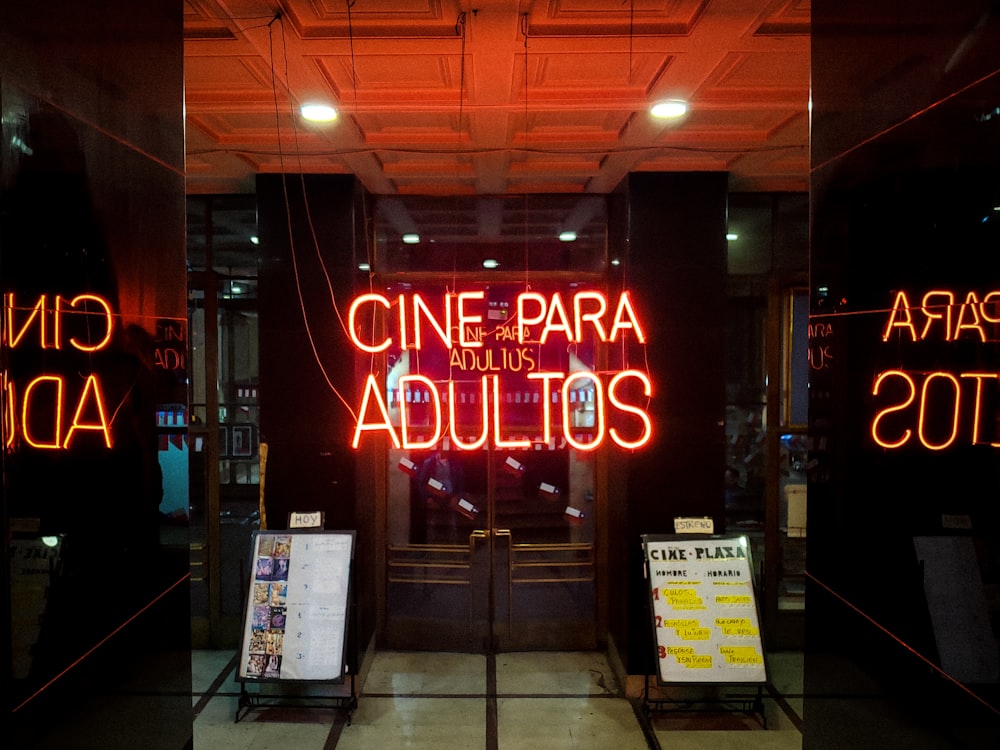 Insegne al neon Cine PAra Adultos davanti alle porte francesi chiuse