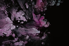 Swirling patterns of pink and white resemble abstract blooms against a dark background. The image features organic, bubble-like formations with delicate marbling textures.