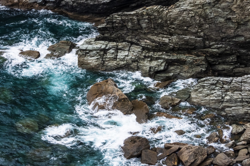 an aerial view of a body of water near rocks