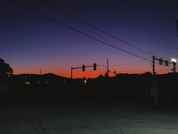 A quiet street corner in Mumbai at dusk, shadows stretching across textured walls.