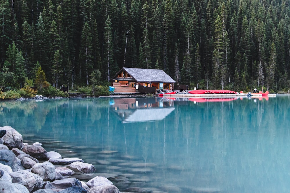 reflection of a house and boats on body of water