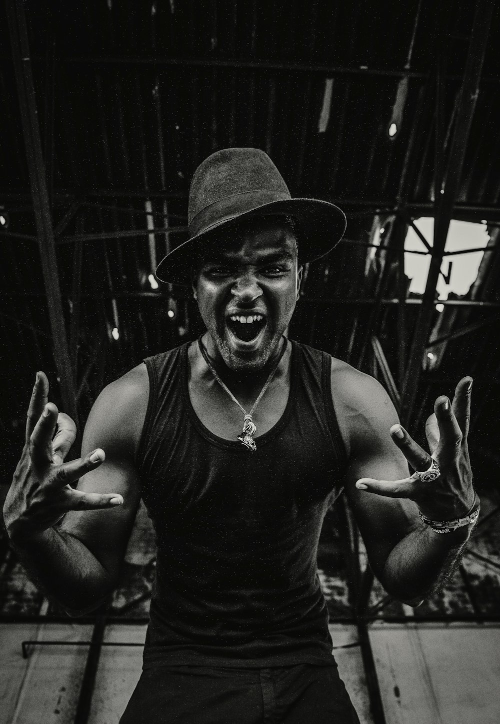 grayscale photography of shouting man in tank top