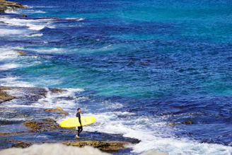 An oceánika speaker perched on a surfboard by the shore, ready for an adventurous day