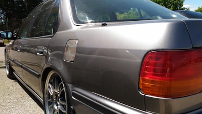 A shiny rear bumper fitted perfectly on a silver car parked outside the shop in Thirumangalam.