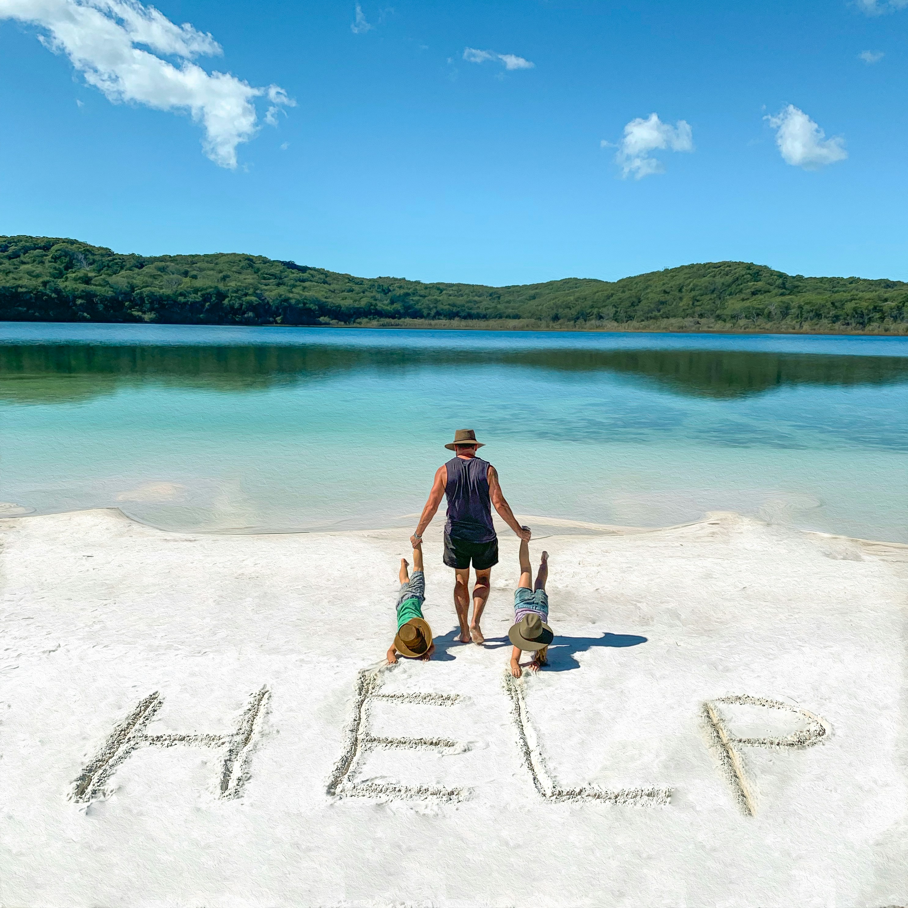 hombre con camisa negra sin mangas tirando de dos niños pequeños durante el día