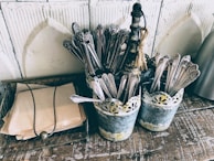 Vintage-style metal utensils with patina, arranged artfully on a linen cloth.