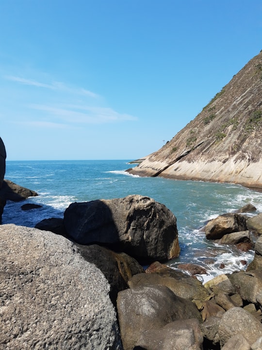 boulders in sea under blue sky in Niterói Brasil