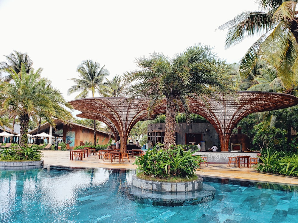 two brown huts beside pool