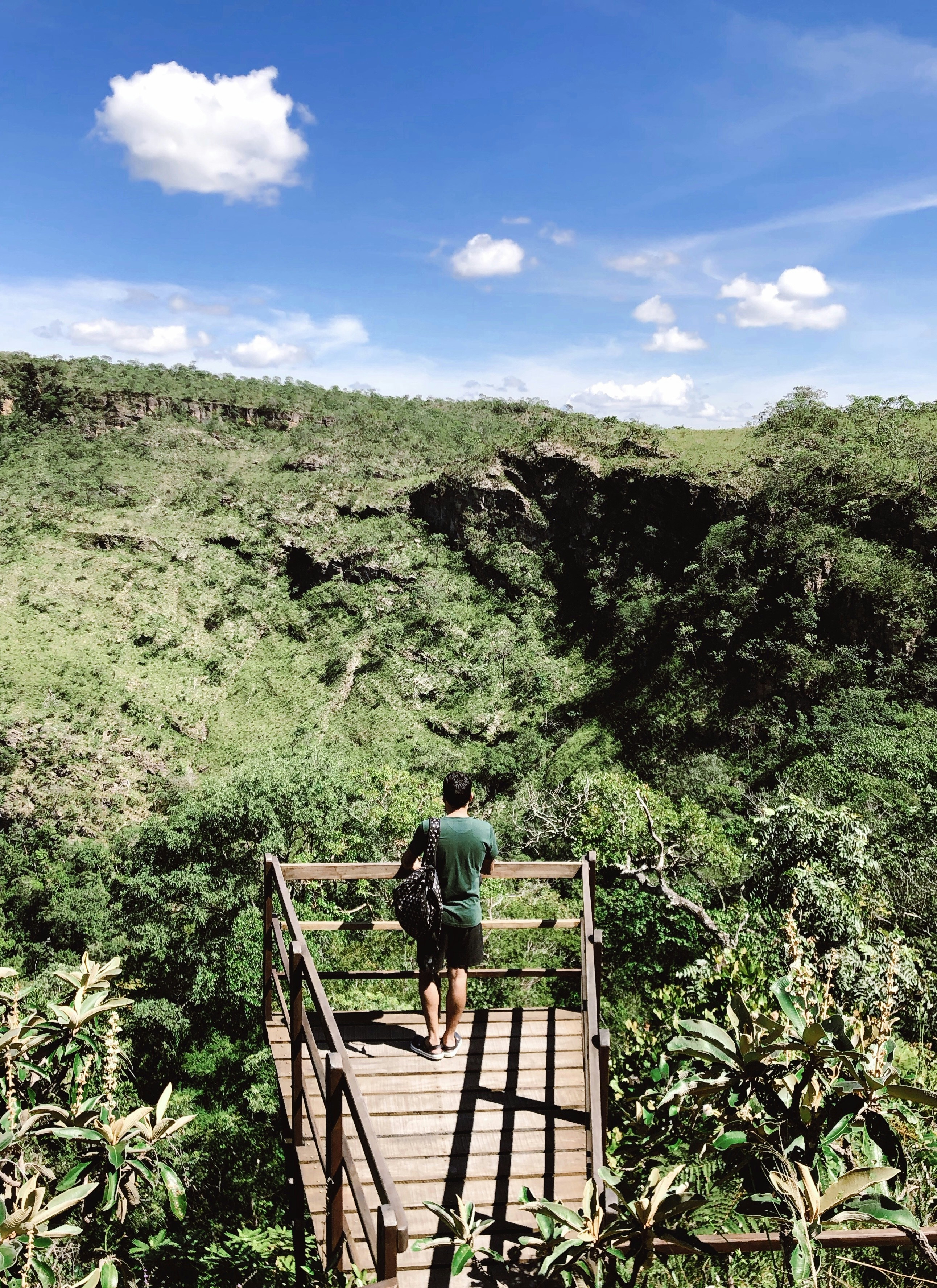 man standing on wooden bridge during daytime