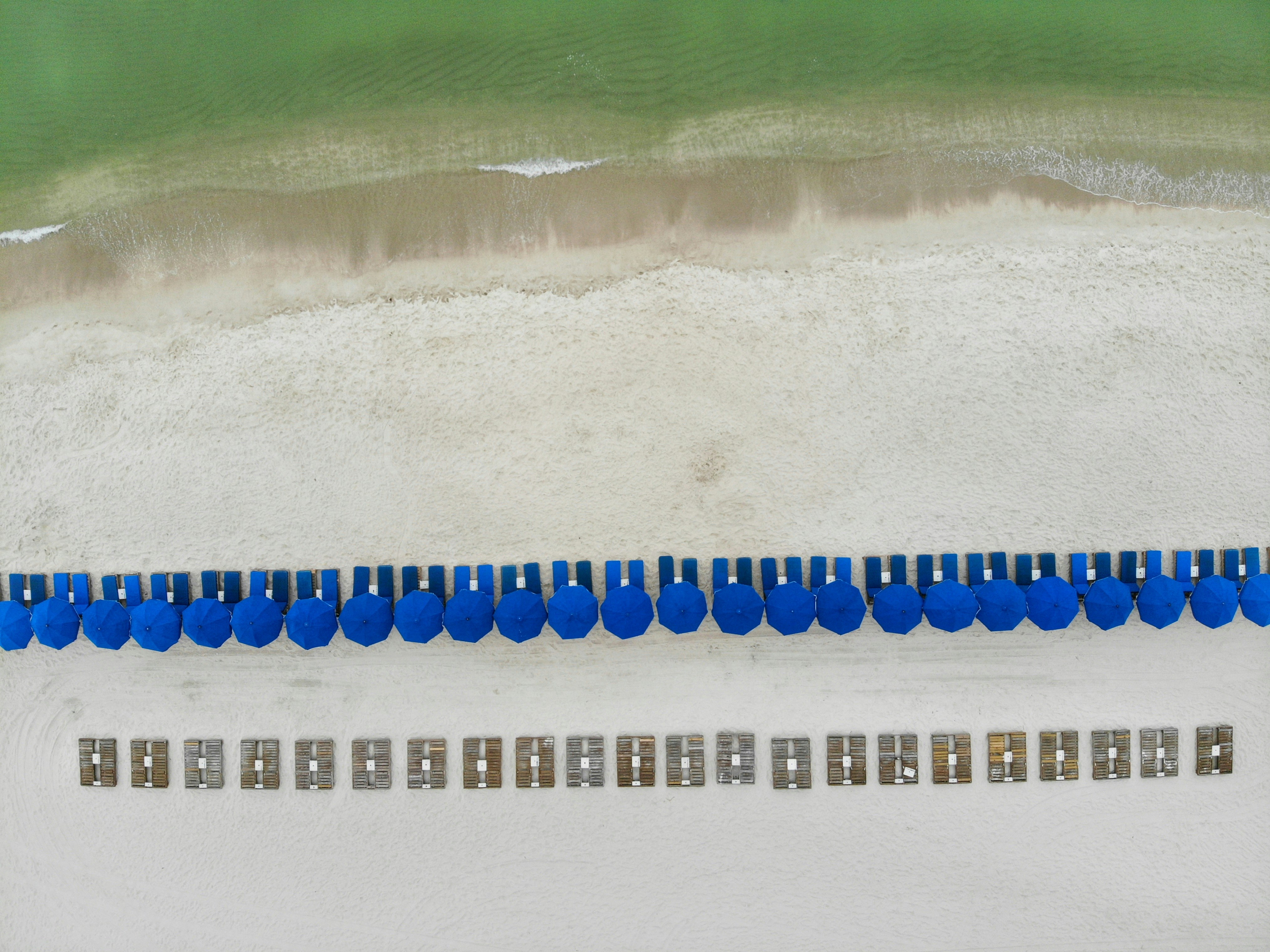 Blue lounge chairs line the beach.