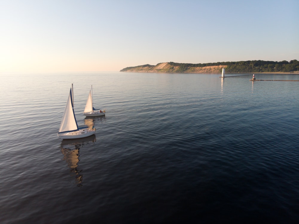 two white sailboats on sea