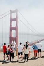 A vibrant group of Korean tourists enjoying a sunny day at the Golden Gate Bridge in San Francisco.