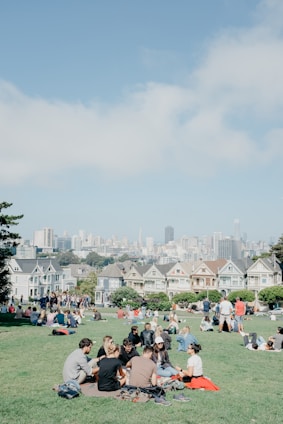 A friendly group of Detroiters enjoying a sunny day at a Dallas park, chatting and sharing stories.