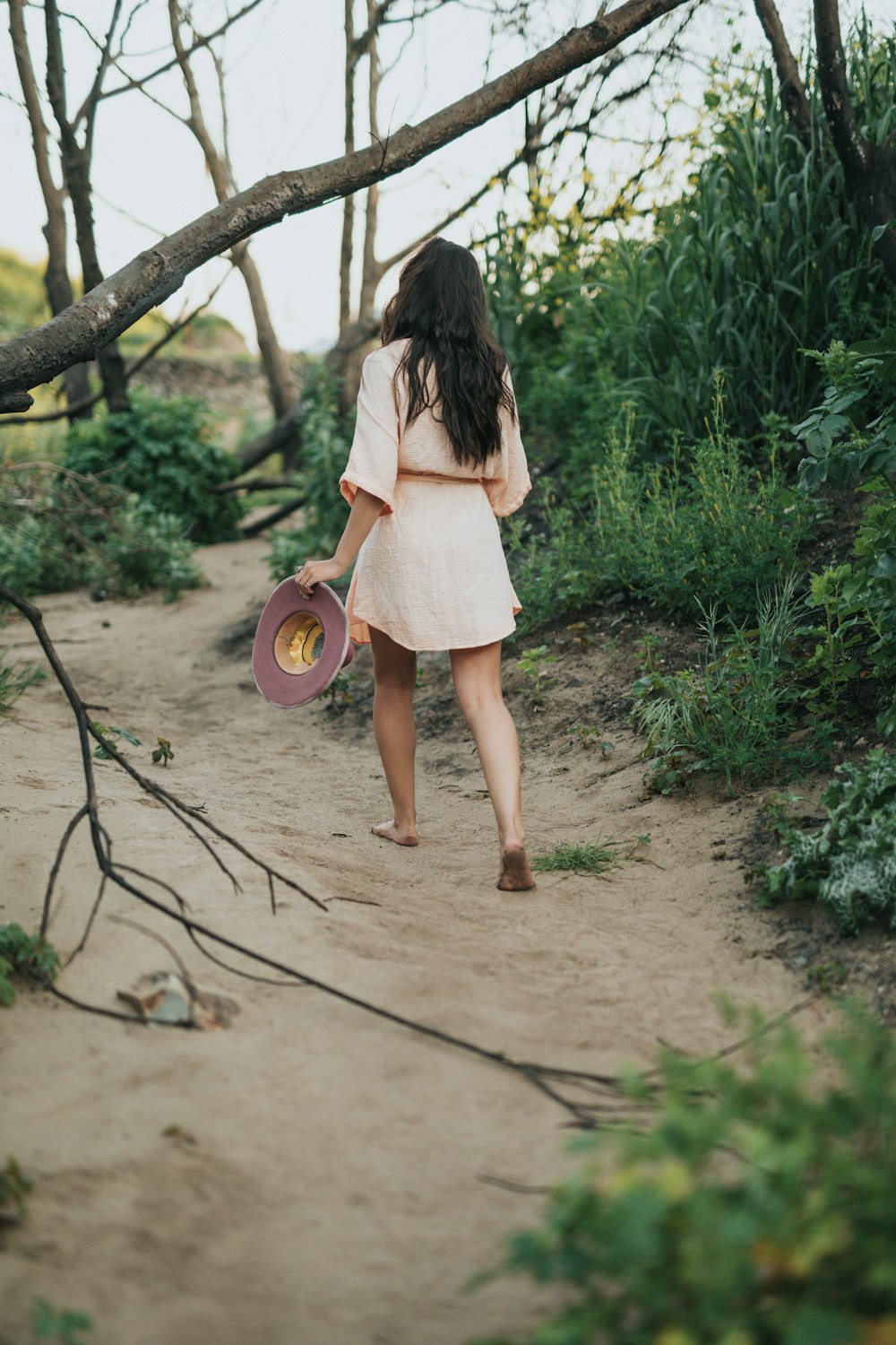 barefoot woman holding hat