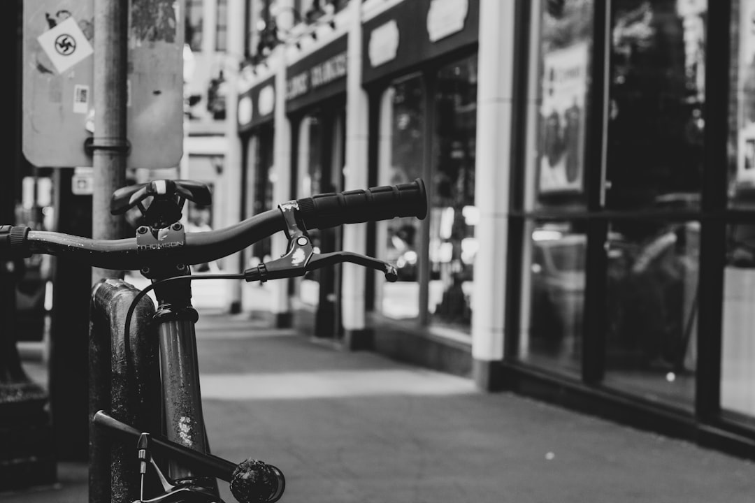 grayscale photography of bicycle beside bar