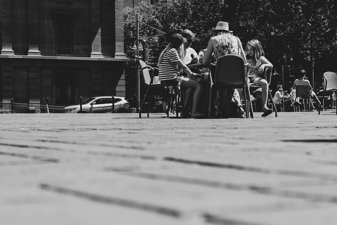 grayscale photo of people sitting at table