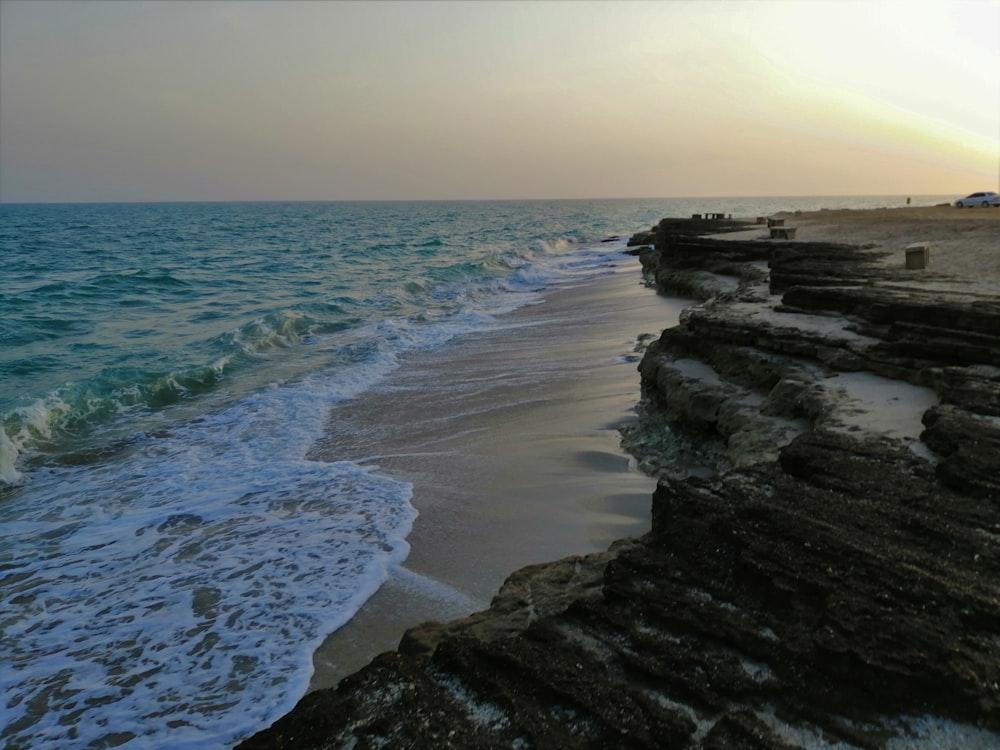 beach cliff viewing calm sea during daytime