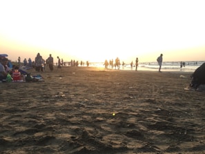 Sunset over Bournemouth beach with families enjoying the sandy shore and calm waves