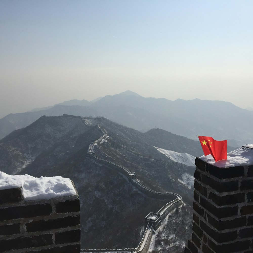 Fotografía aérea de una bandera roja en lo alto de un muro de piedra