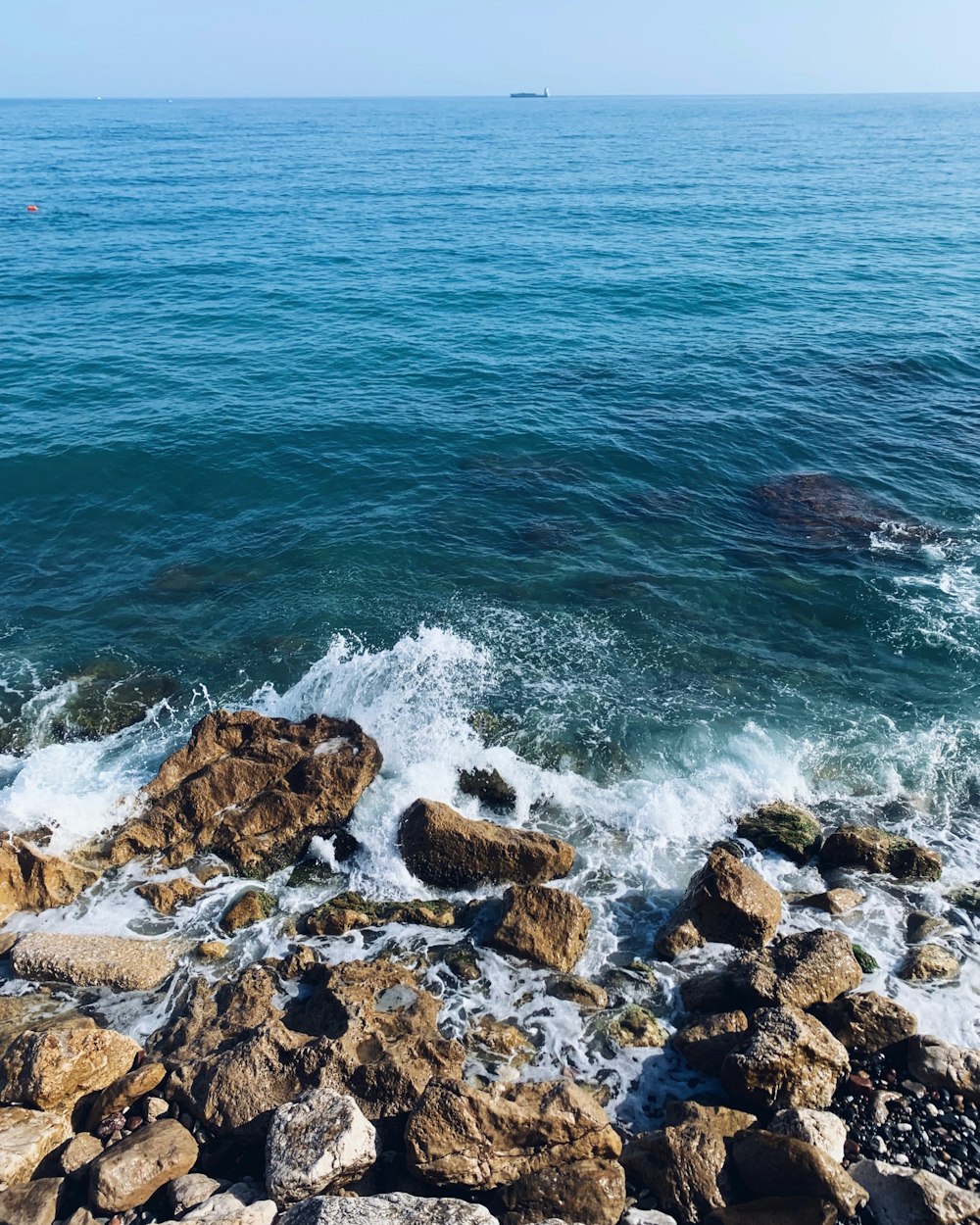 Roches brunes au bord de la mer bleue pendant la journée