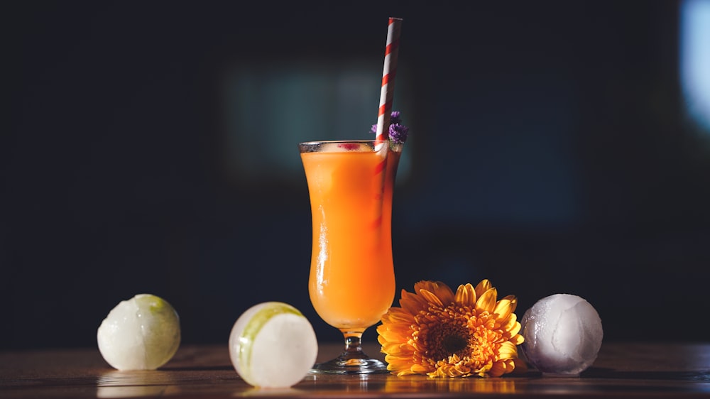 shallow focus photo of orange liquid in clear glass cup