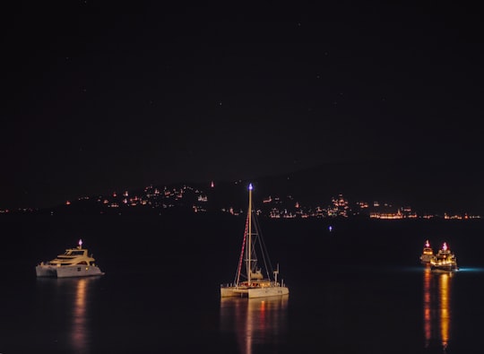 several boats floating in the sea during nighttime in Saranda Albania