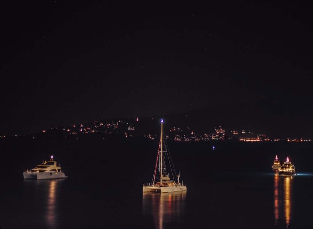several boats floating in the sea during nighttime