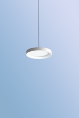 Minimalist pendant light fixture hanging over a dining table.