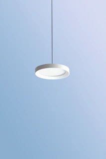 A modern black pendant necklace hanging against a minimalist white background