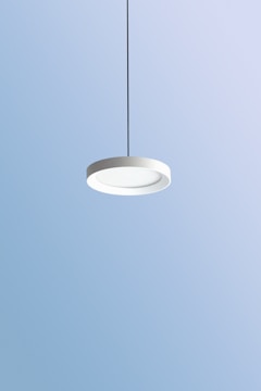 Minimalist pendant light fixture hanging over a dining table.
