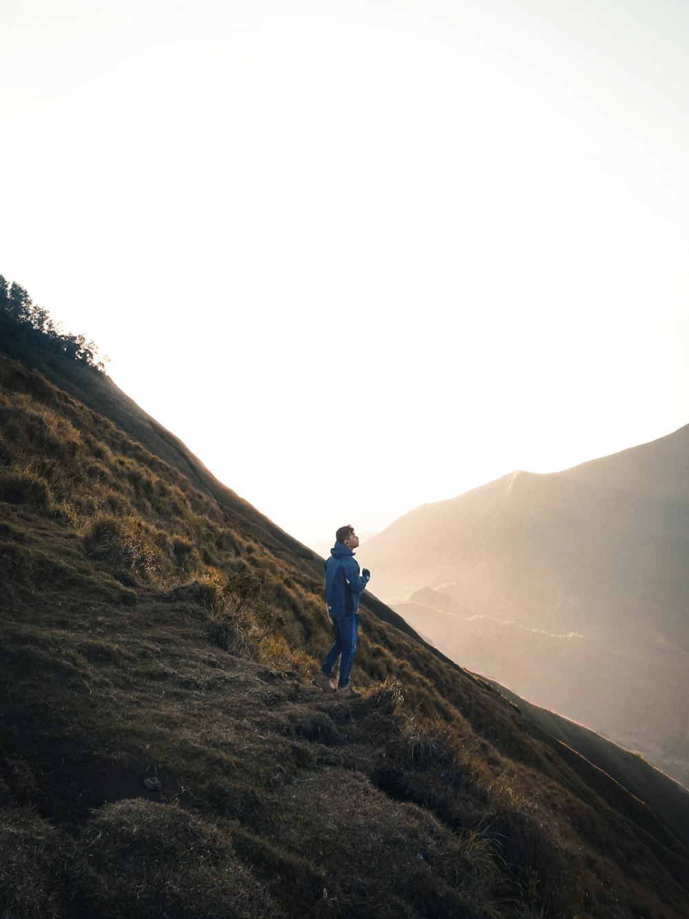 man standing on mountain at daytime