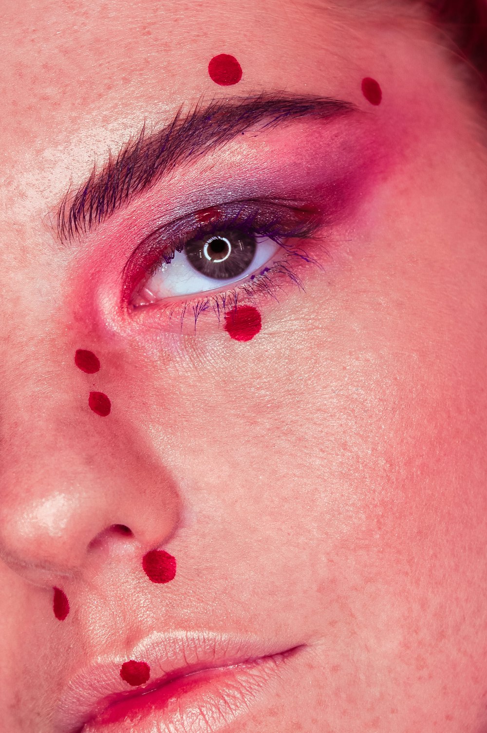 a close up of a woman's face with dots on her cheek