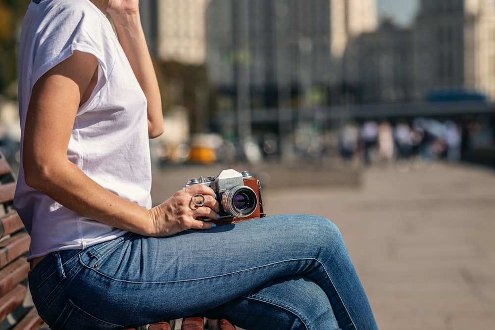 woman sitting on bench and holding camera
