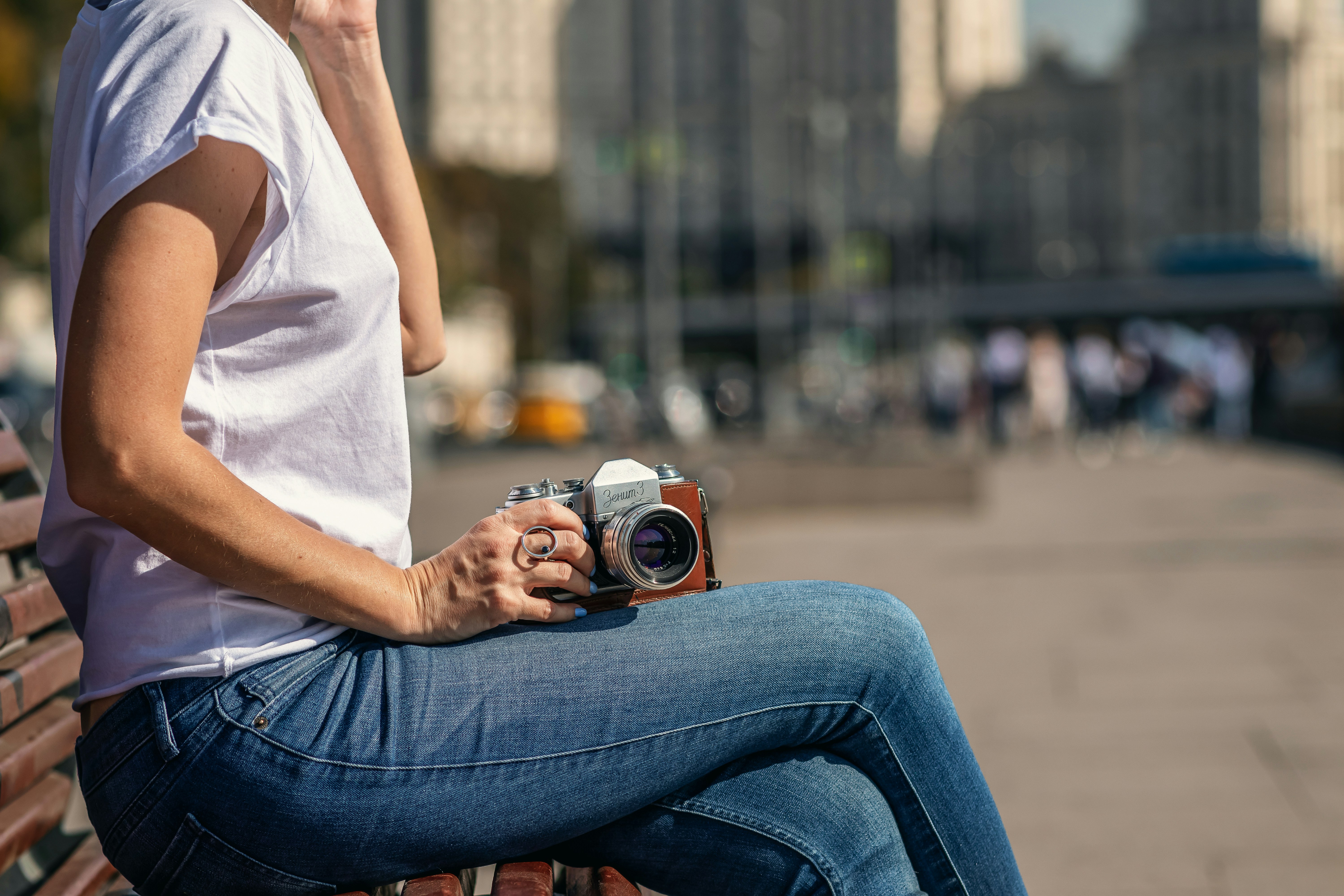 woman sitting on bench and holding camera