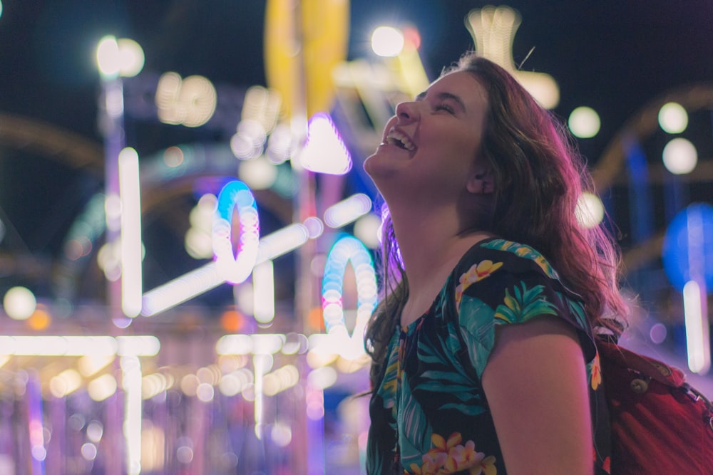 woman smiling black and green floral shirt at night