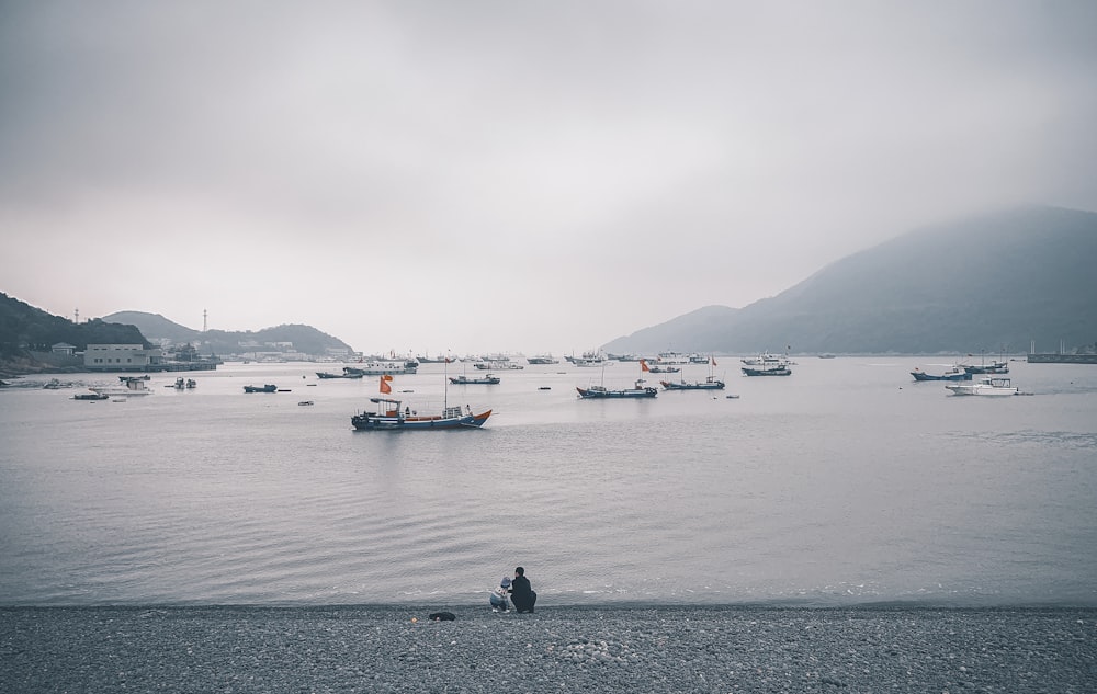 boats on body of water under cloudy sky
