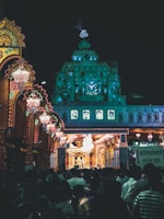 Night scene of a temple illuminated with festive lights during a pilgrimage festival.