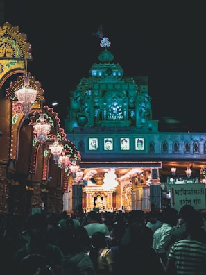 Night scene of a temple illuminated with festive lights during a pilgrimage festival.