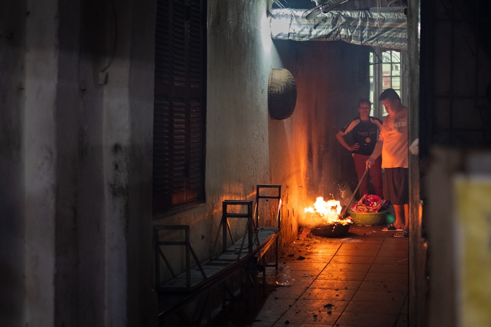 person in orange shirt in front of fire