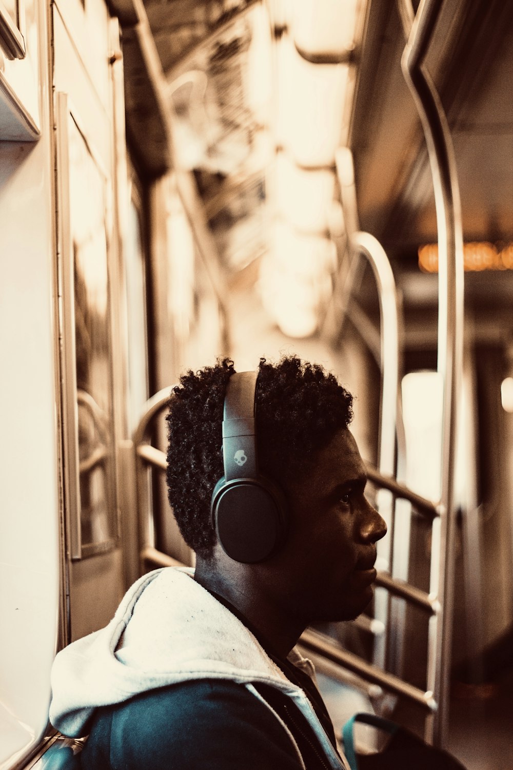 man sitting and wearing headphones inside train