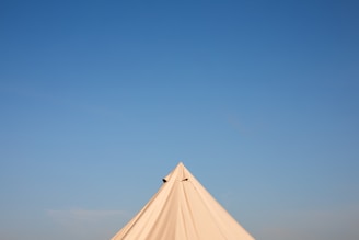 Close-up of a pyramid tent’s sturdy frame and pristine white fabric.