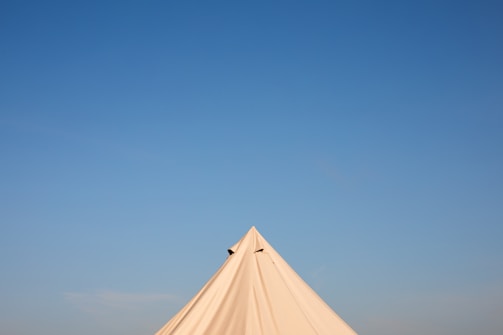 Close-up of a pyramid tent’s sturdy frame and pristine white fabric.