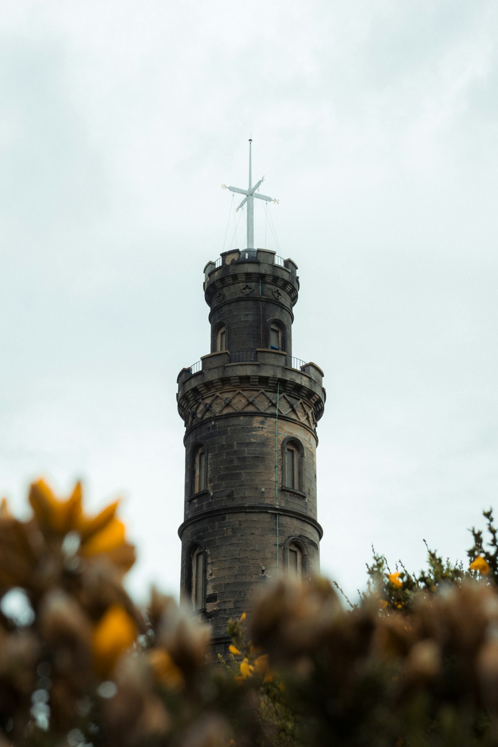 a tall tower with a cross on top of it