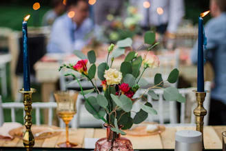 A vibrant floral arrangement centerpiece on a rustic wooden table at a cozy home event.