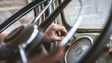 Close-up of hands using diagnostic tools on a camper van's dashboard.