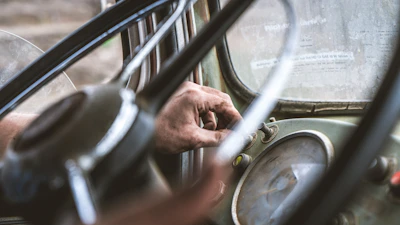 Close-up of hands using diagnostic tools on a camper van's dashboard.