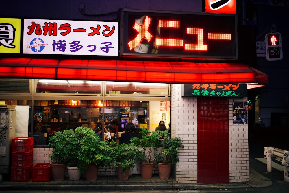 a restaurant with a neon sign above it's entrance