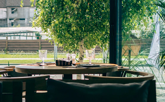 A cozy outdoor dining setup with delicious Indonesian dishes and fresh drinks on a wooden table.