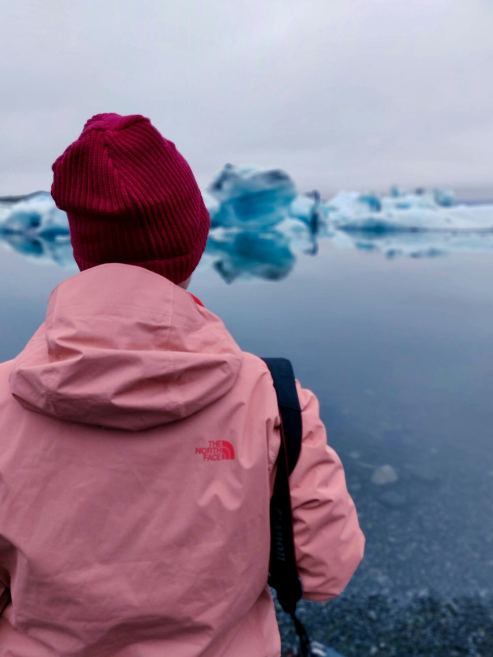 persona desconocida con sudadera con capucha roja de The North Face